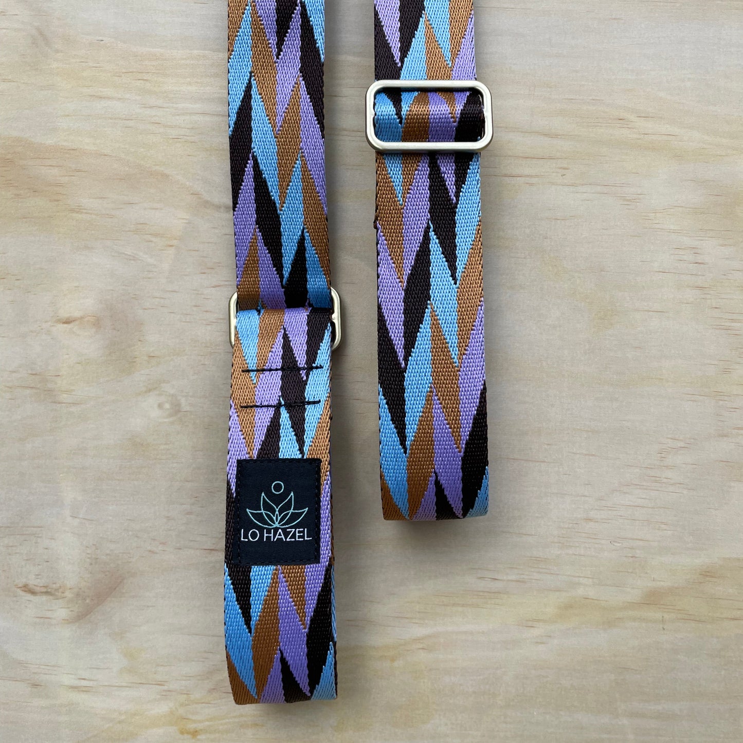 Geometric patterned belt with a buckle on a wooden surface